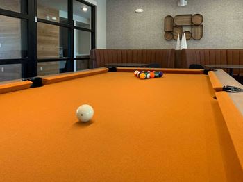 a close-up shot of a pool table with orange felt